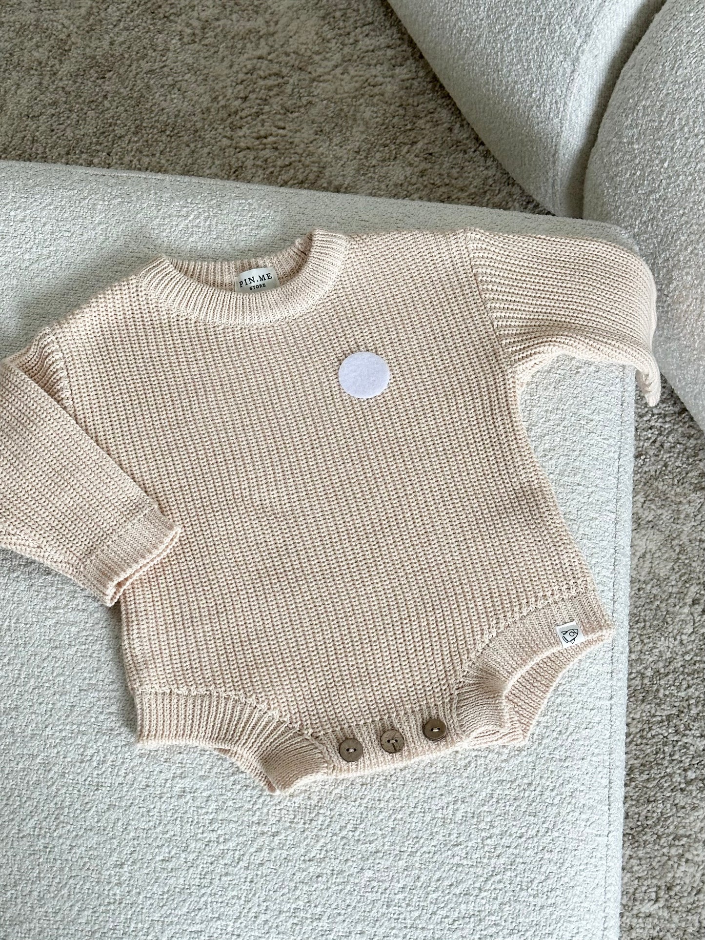 Beige knitted baby romper and 2 changeable decorations