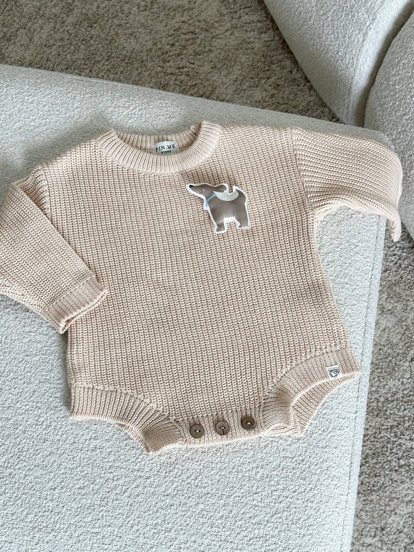 Beige knitted baby romper and 2 changeable decorations