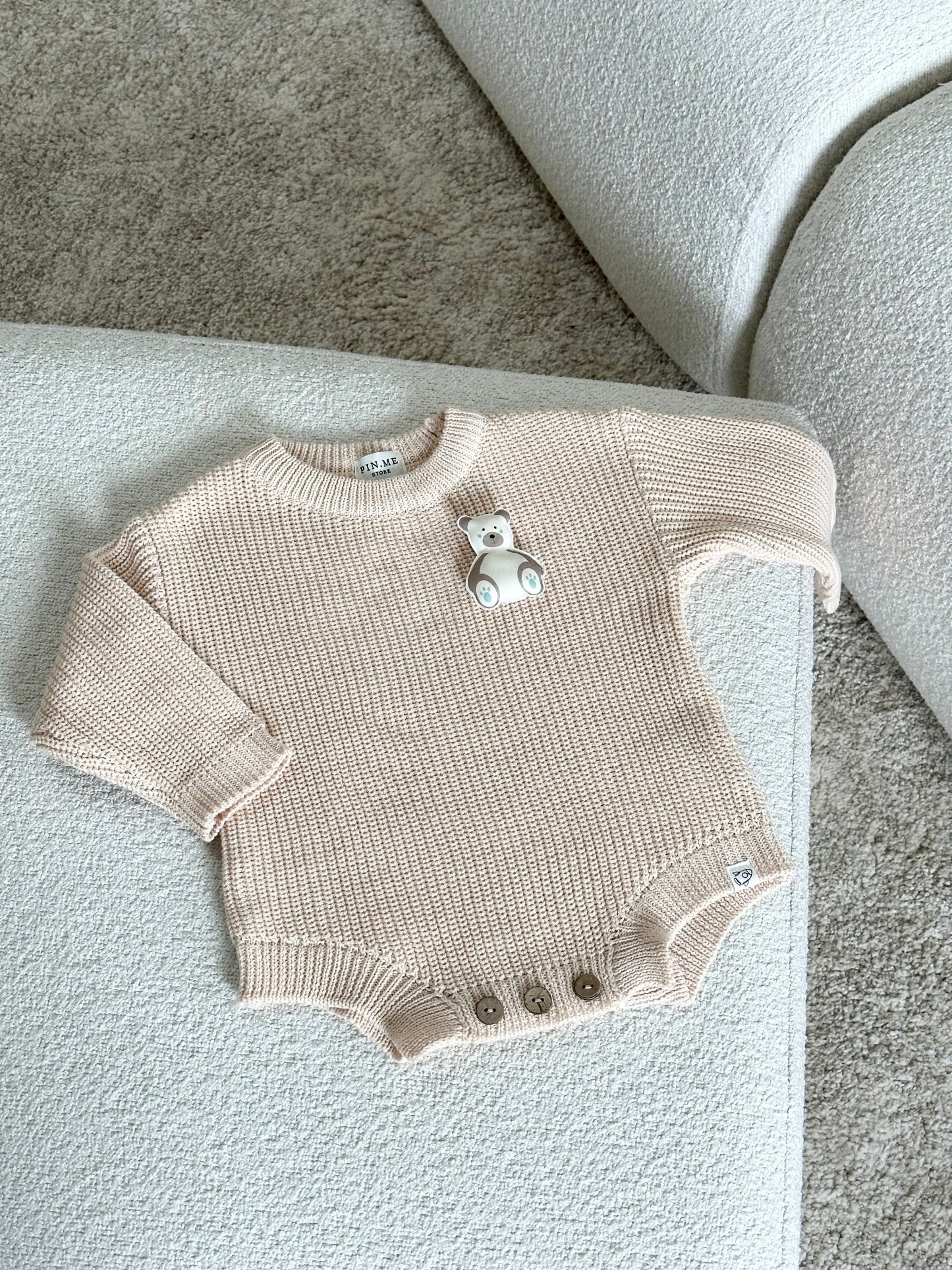 Beige knitted baby romper and 2 changeable decorations