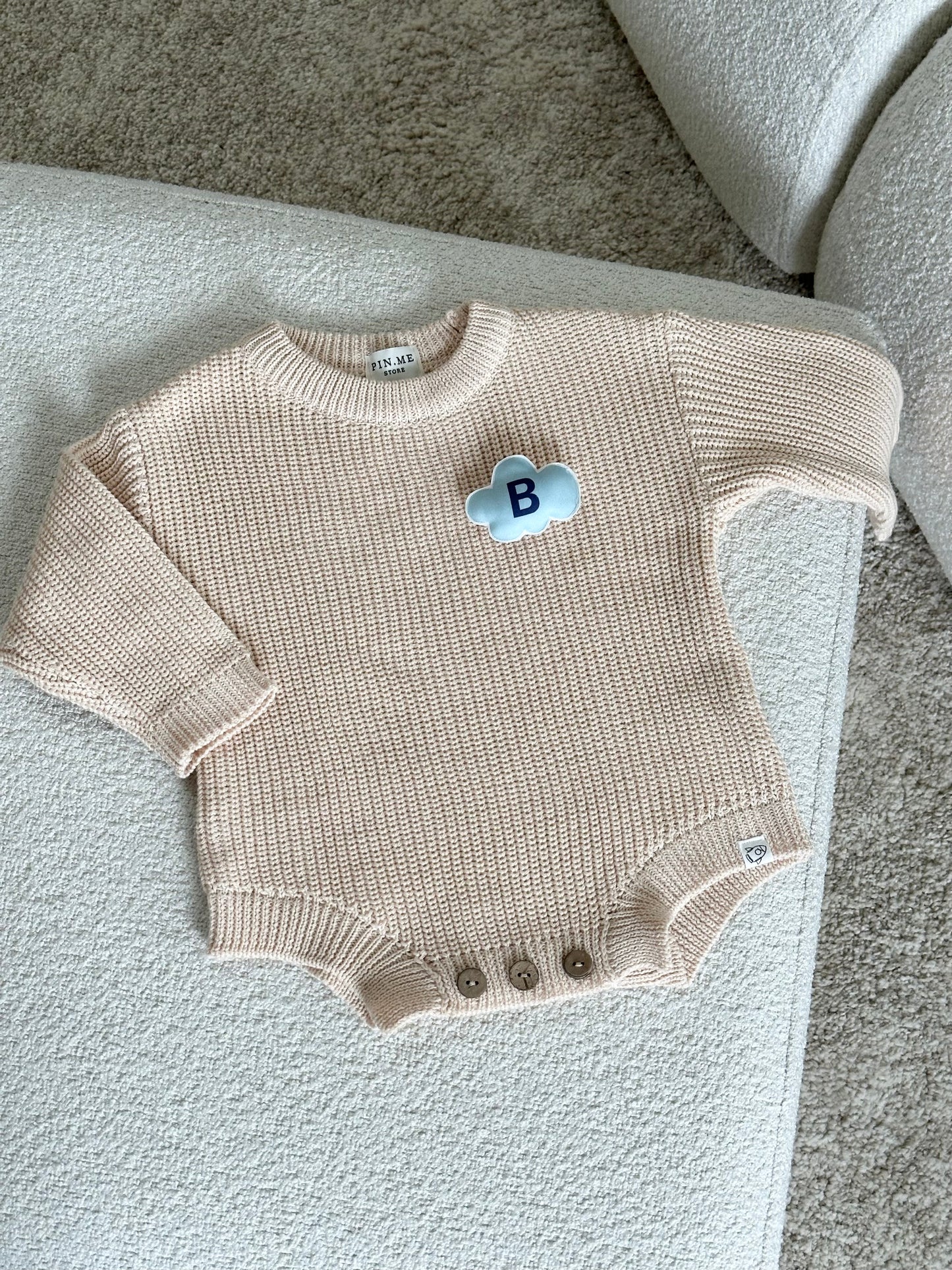 Beige knitted baby romper and 2 changeable decorations